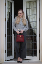 a lady in a white lapel shirt, a grey cardigan and a pair of grey pants